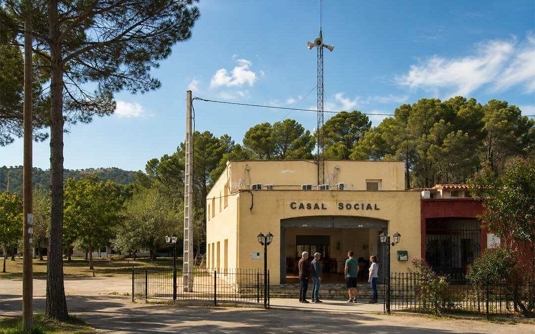 Casal Social de Les Planes del Rei avec le volet ouvert et plusieurs habitants réunis devant le bâtiment.